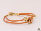 Adjustable double string orange bracelet with twin T motifs