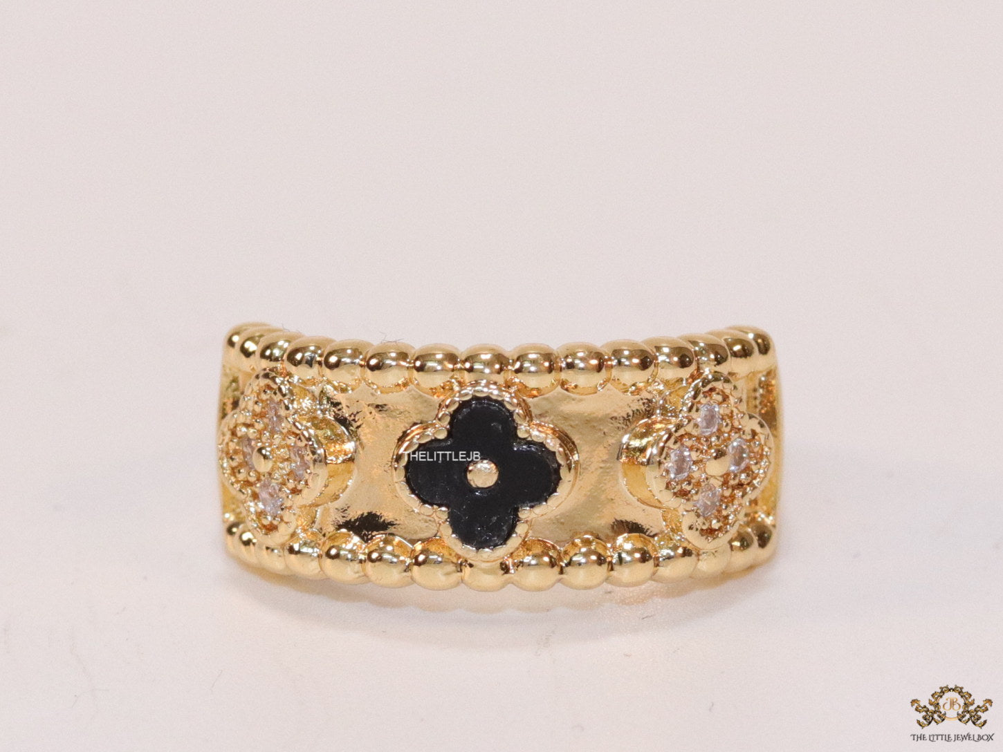 Golden ring band with black enamel and cz clovers