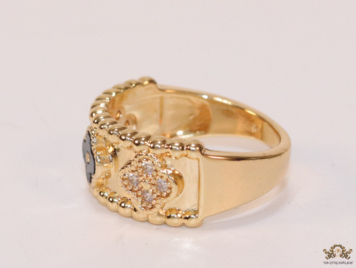 Golden ring band with black enamel and cz clovers