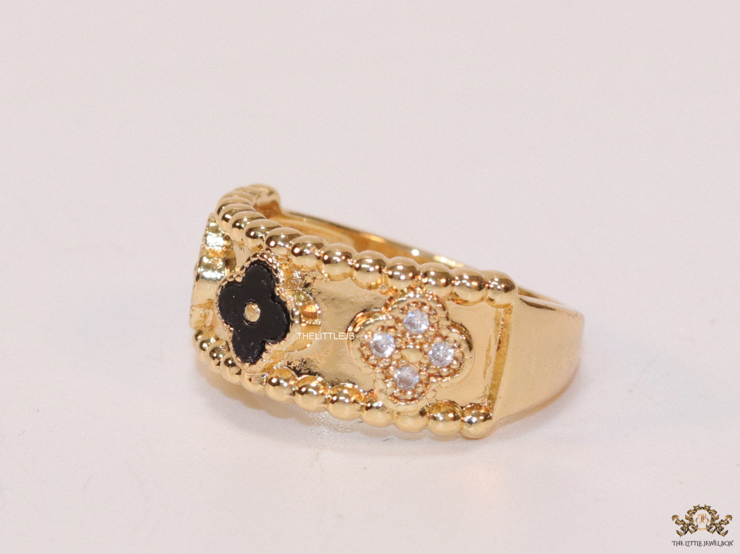 Golden ring band with black enamel and cz clovers