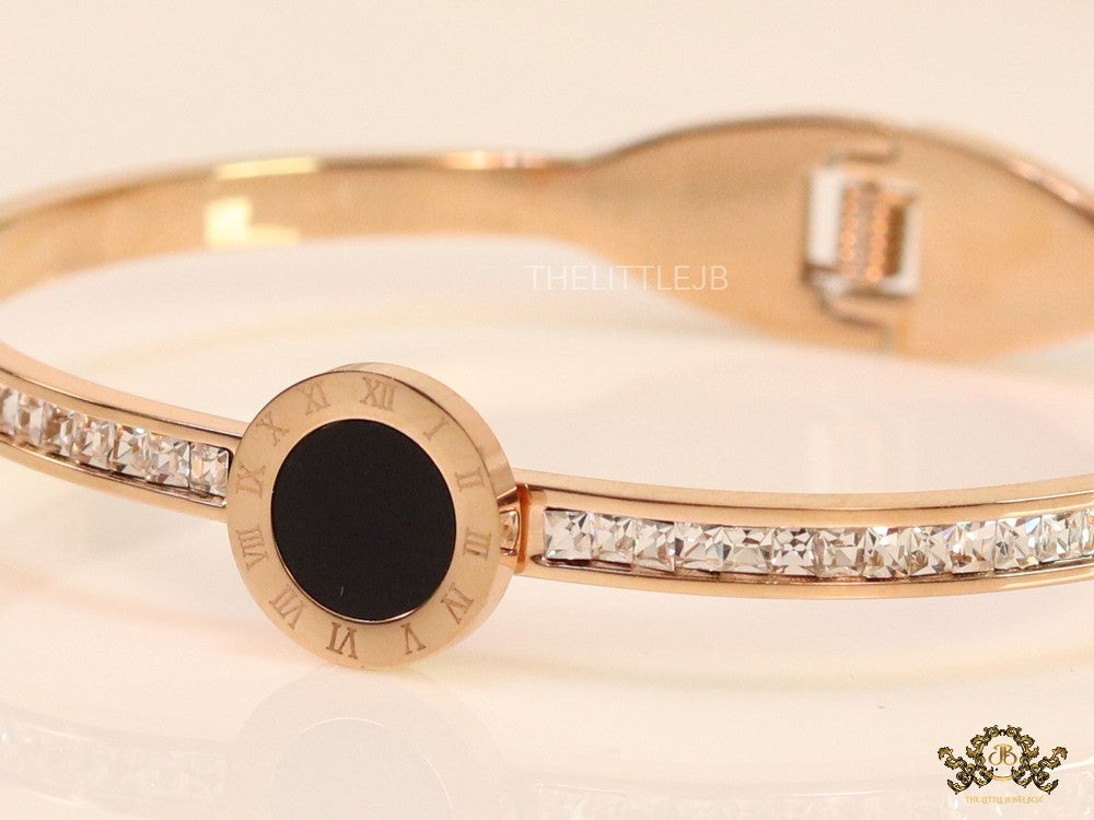 Rose gold plated cz bracelet with roman numerals inscribed on black centre motif