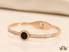 Rose gold plated cz bracelet with roman numerals inscribed on black centre motif