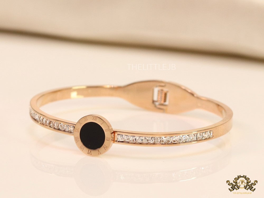 Rose gold plated cz bracelet with roman numerals inscribed on black centre motif