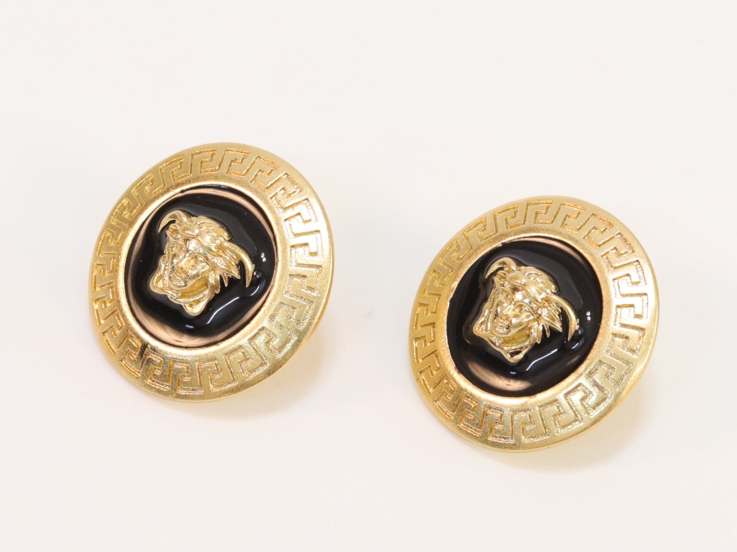 Gold round medusa motif black enamel earrings