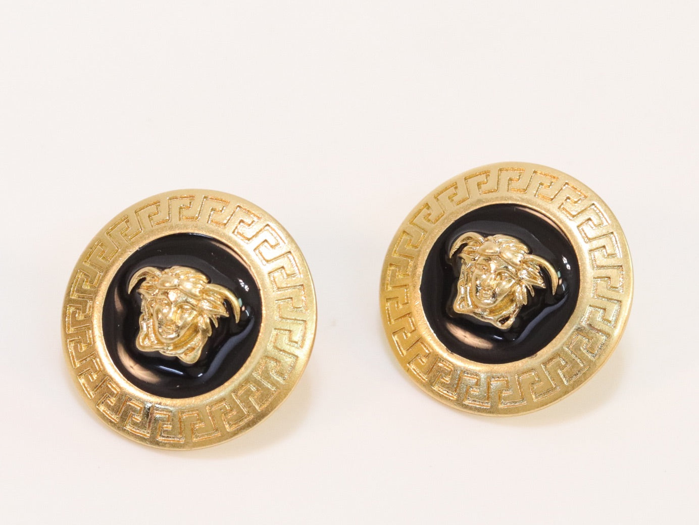 Gold round medusa motif black enamel earrings