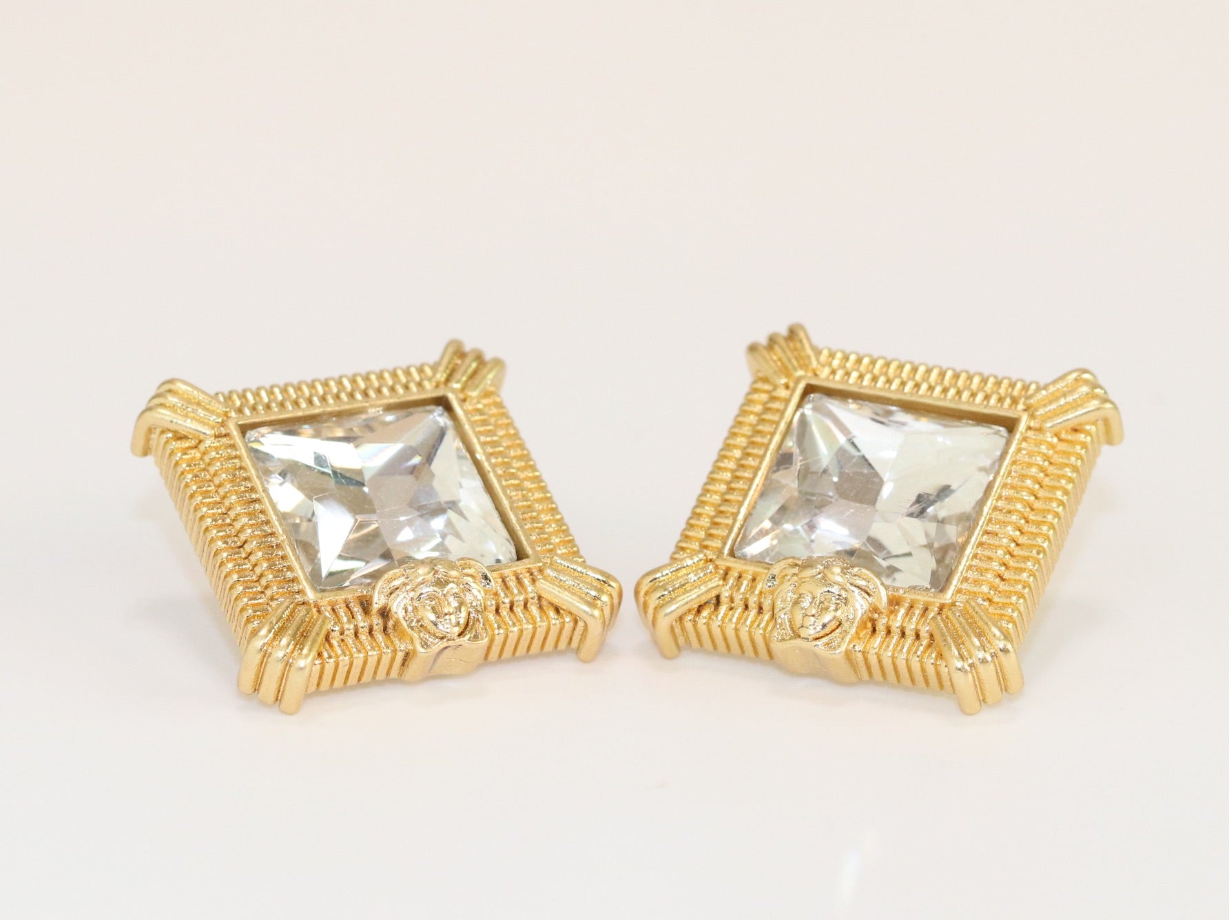 Square solitaires in gold boundaries with medusa