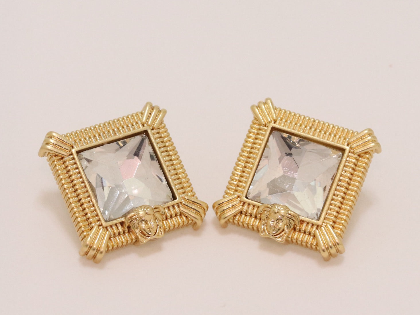 Square solitaires in gold boundaries with medusa