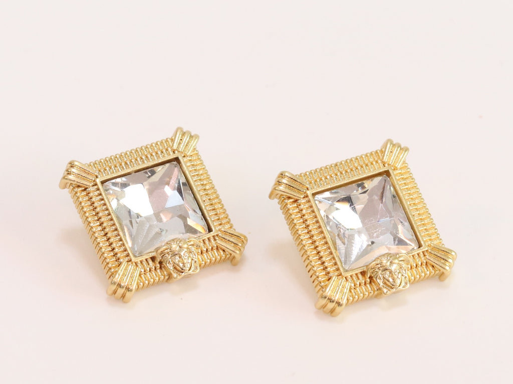 Square solitaires in gold boundaries with medusa