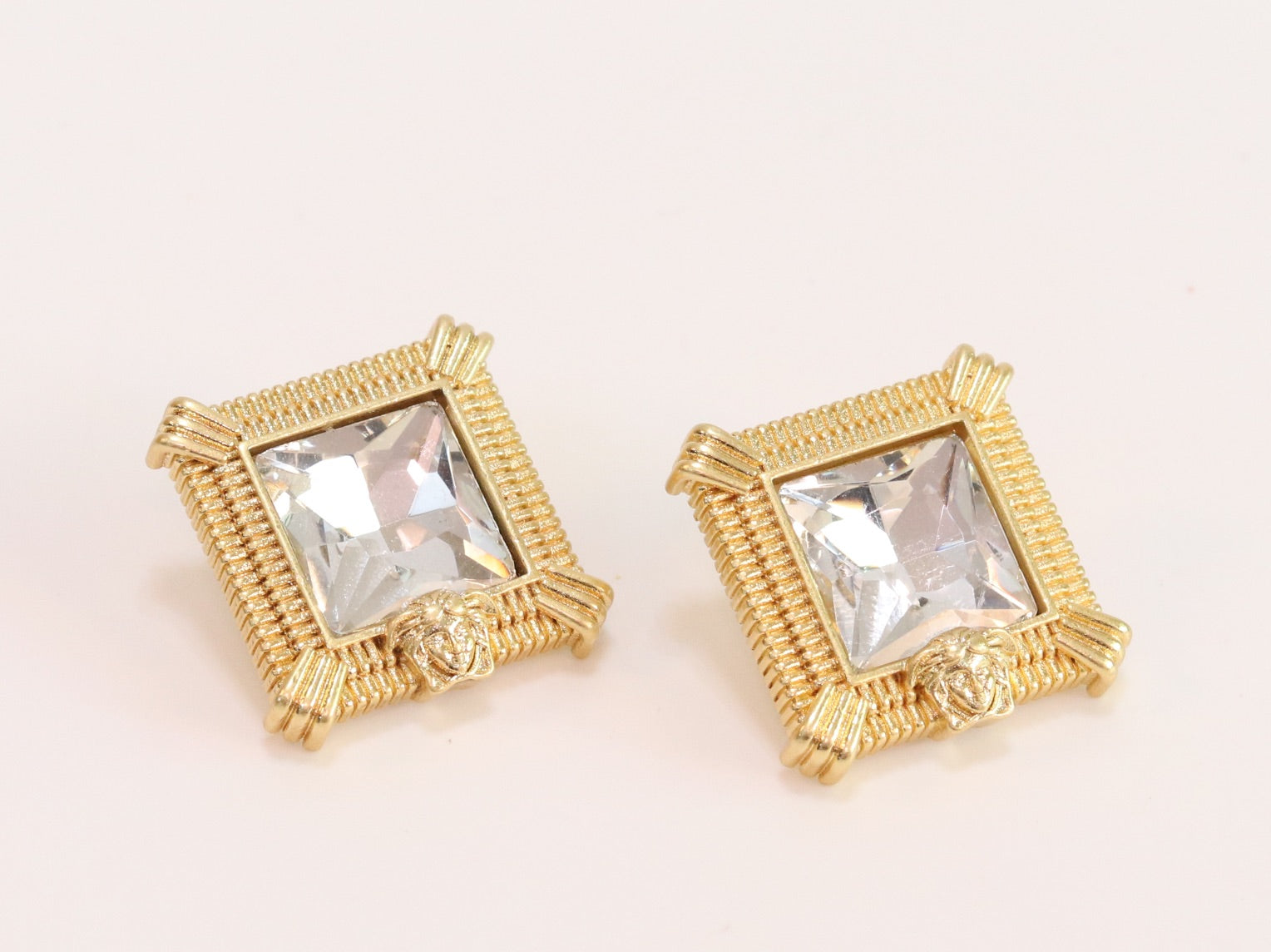 Square solitaires in gold boundaries with medusa