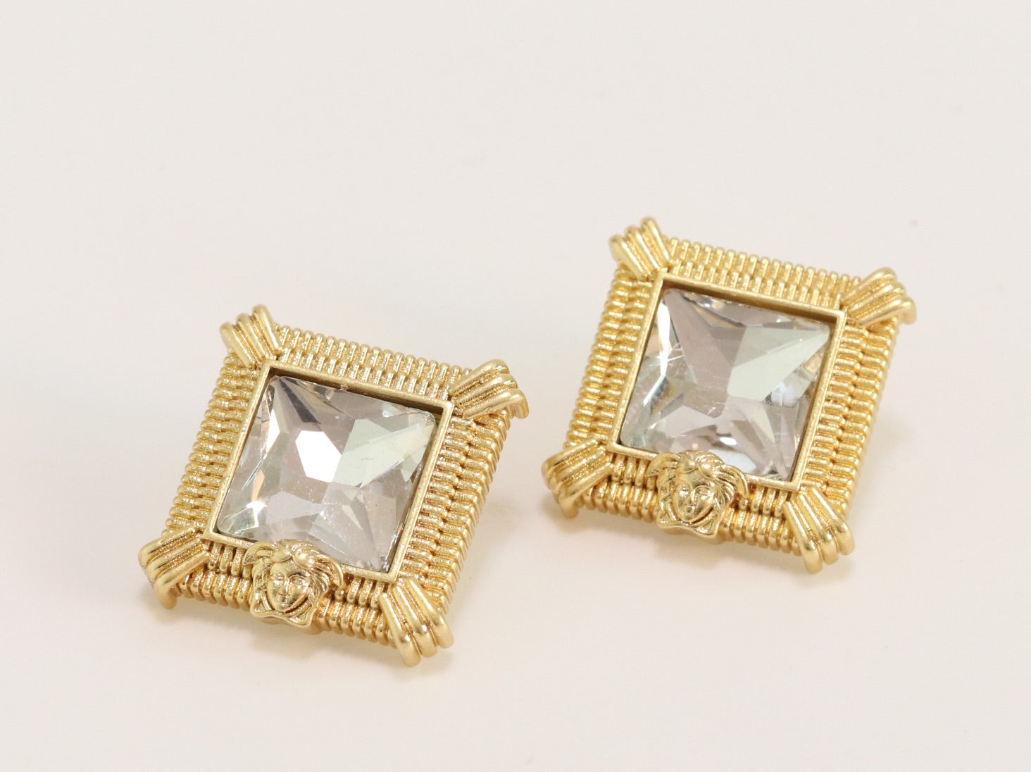 Square solitaires in gold boundaries with medusa