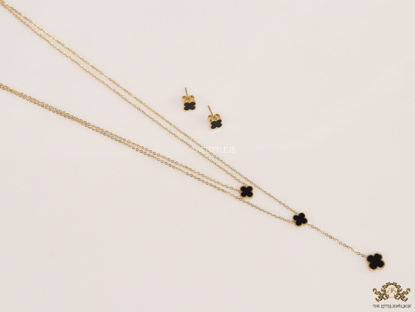 Dual chain necklace with black onyx clovers in gold finish