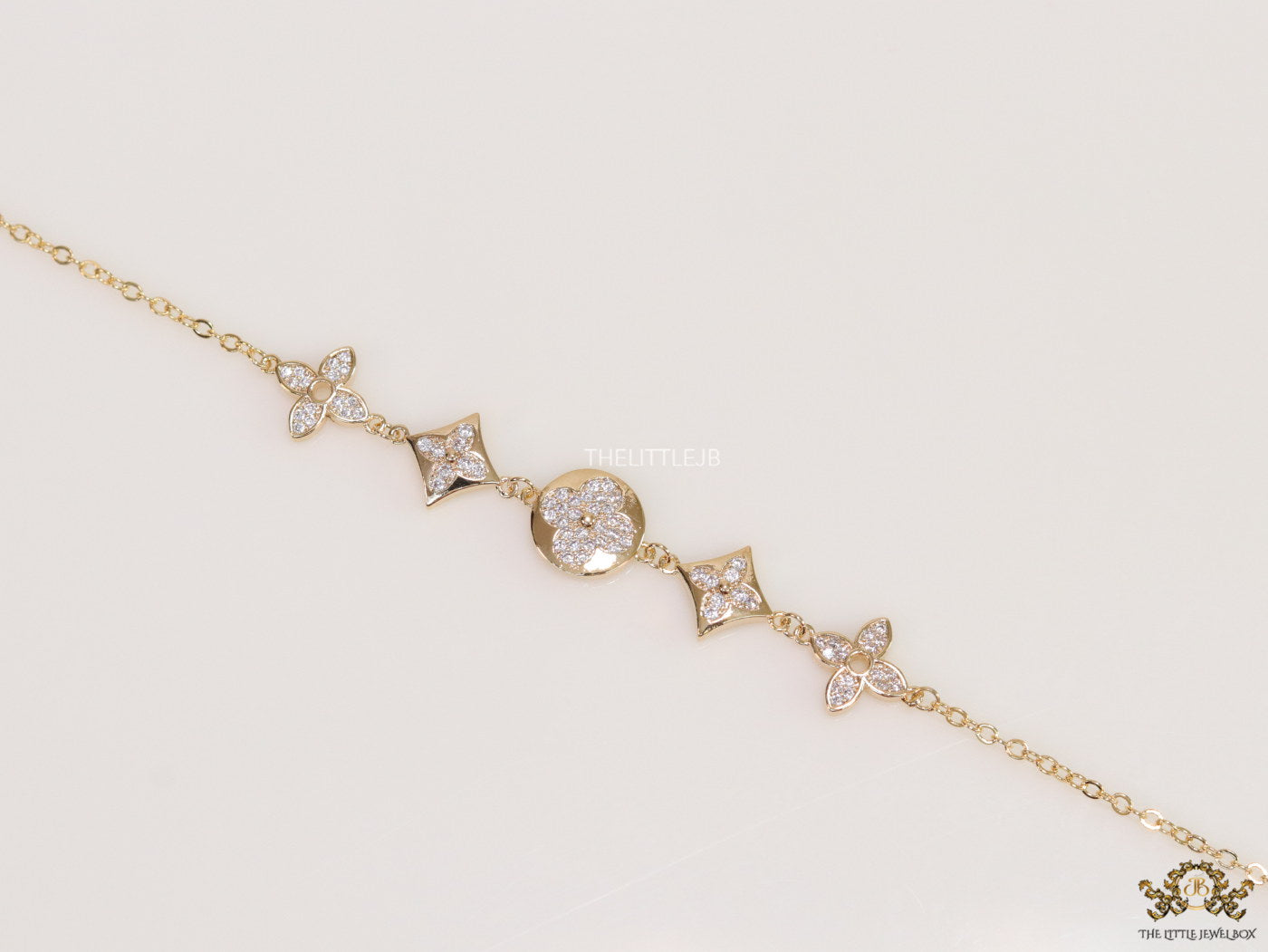 Gold plated chain bracelet with cz clovers and flowers
