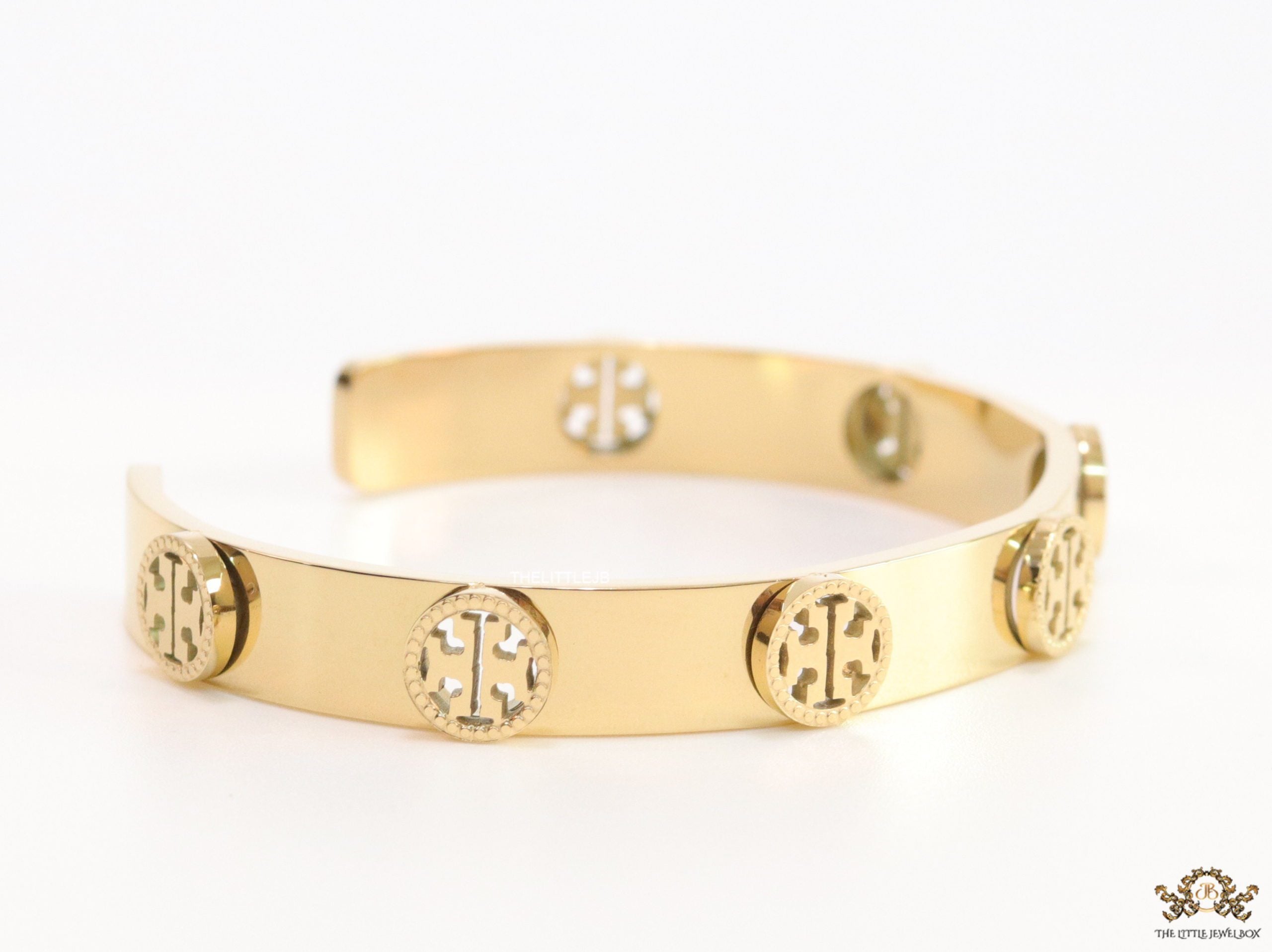 Gold plated open band bracelet with twin T motifs