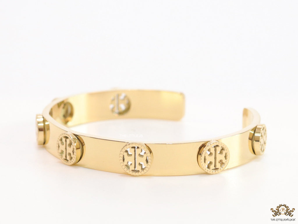 Gold plated open band bracelet with twin T motifs