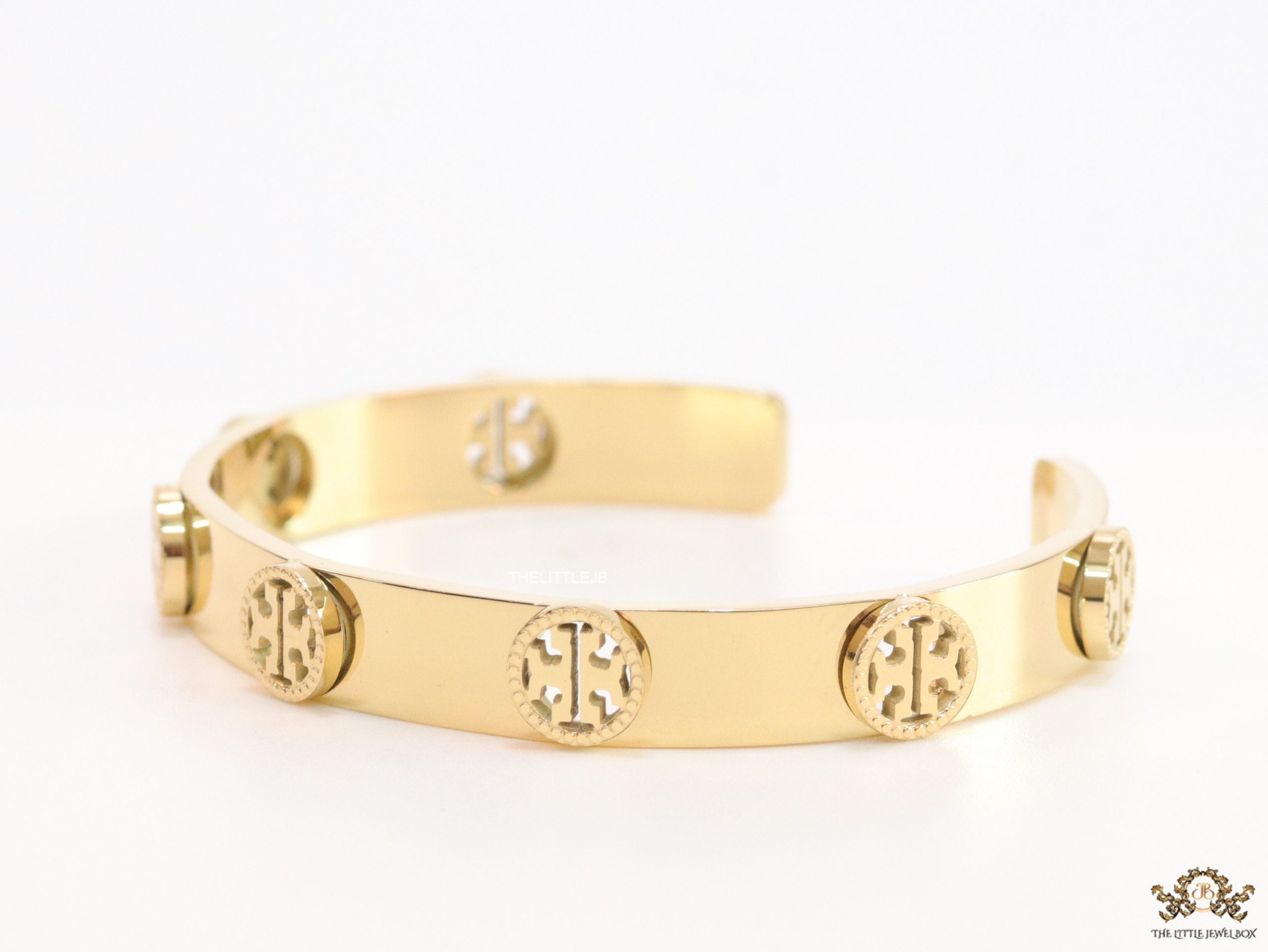 Gold plated open band bracelet with twin T motifs