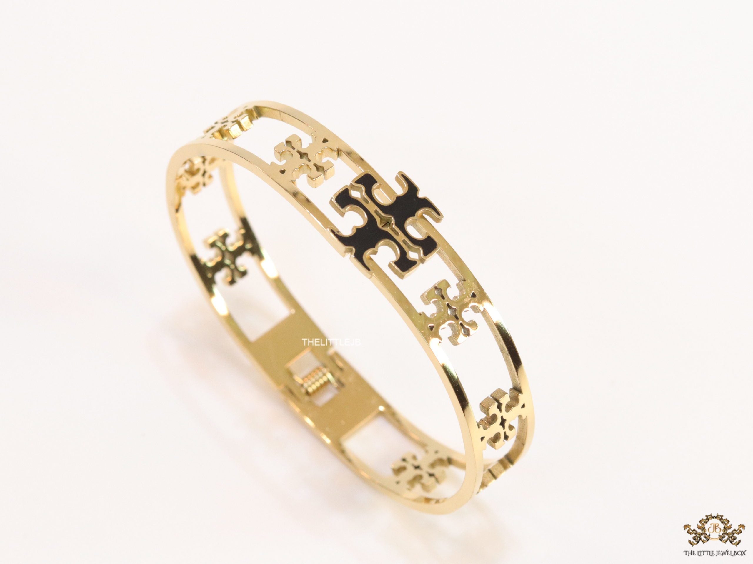 Gold plated openable bracelet with fancy cutwork T motifs