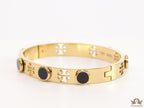 Gold plated cutwork twin T motif bracelet with black stones