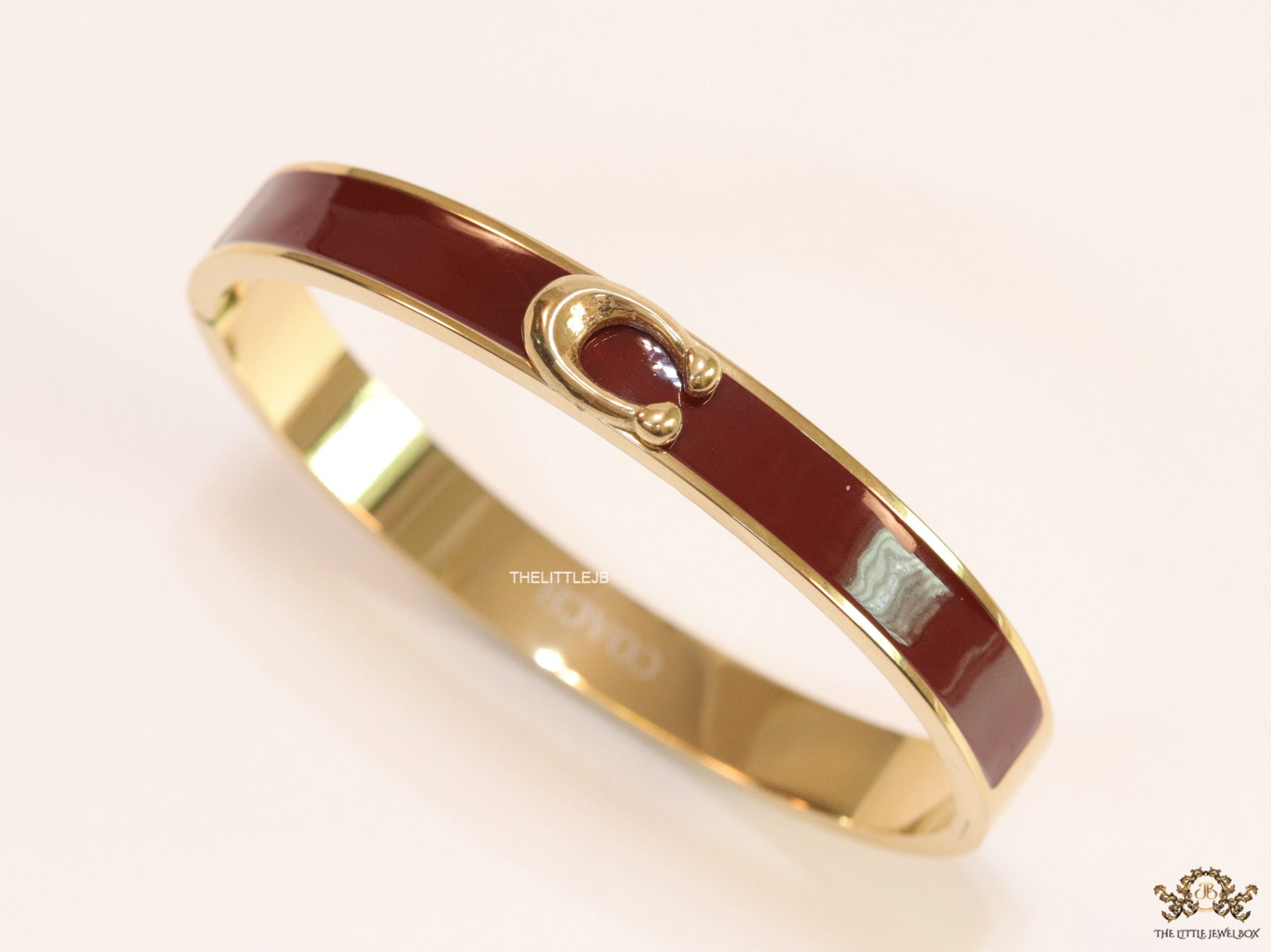 Sleek maroon and golden bracelet with C alphabet in centre