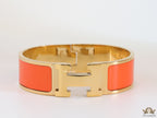 Openable H motif orange bracelet 18mm wide in a shiny gold plating