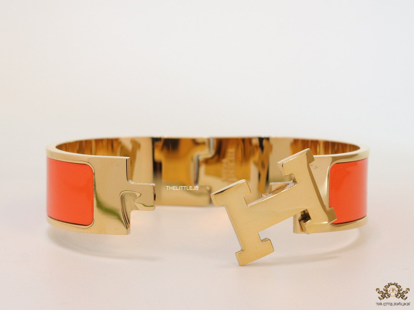 Openable H motif orange bracelet 18mm wide in a shiny gold plating