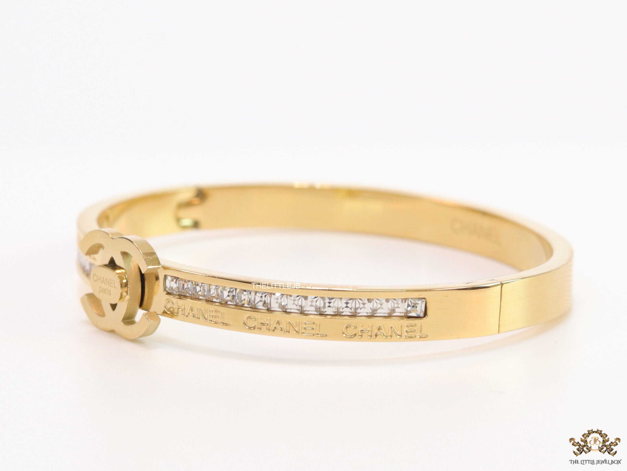Gold plated bracelet with cz, inscribed alphabets and twin disc motif