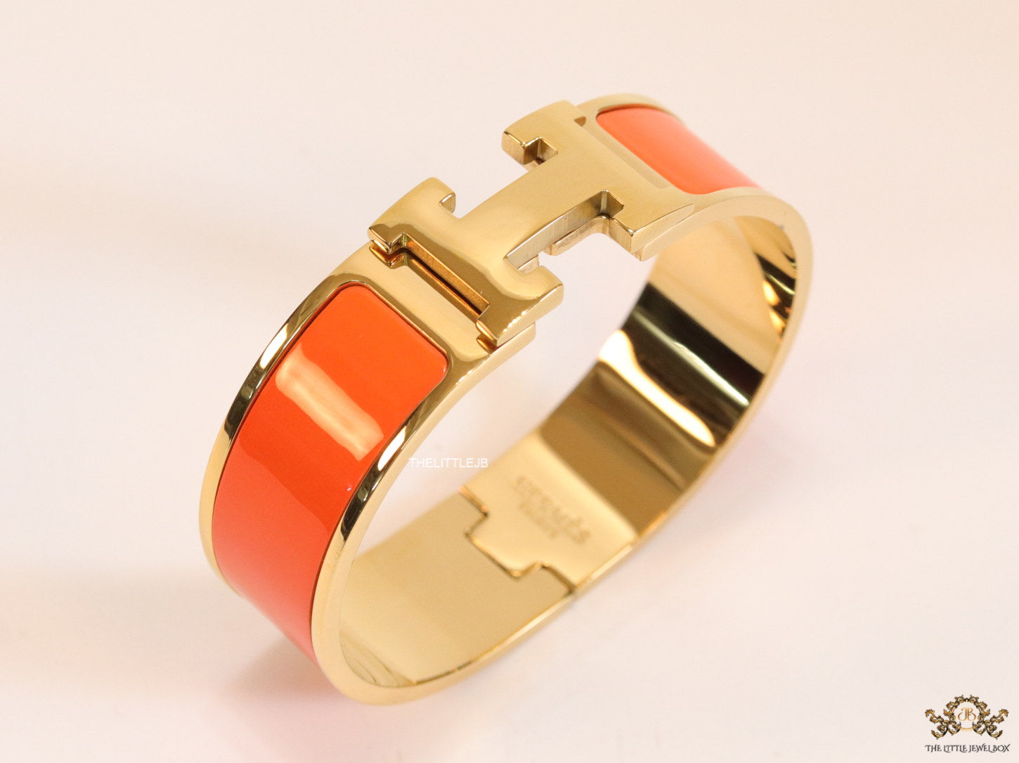 Openable H motif orange bracelet 18mm wide in a shiny gold plating