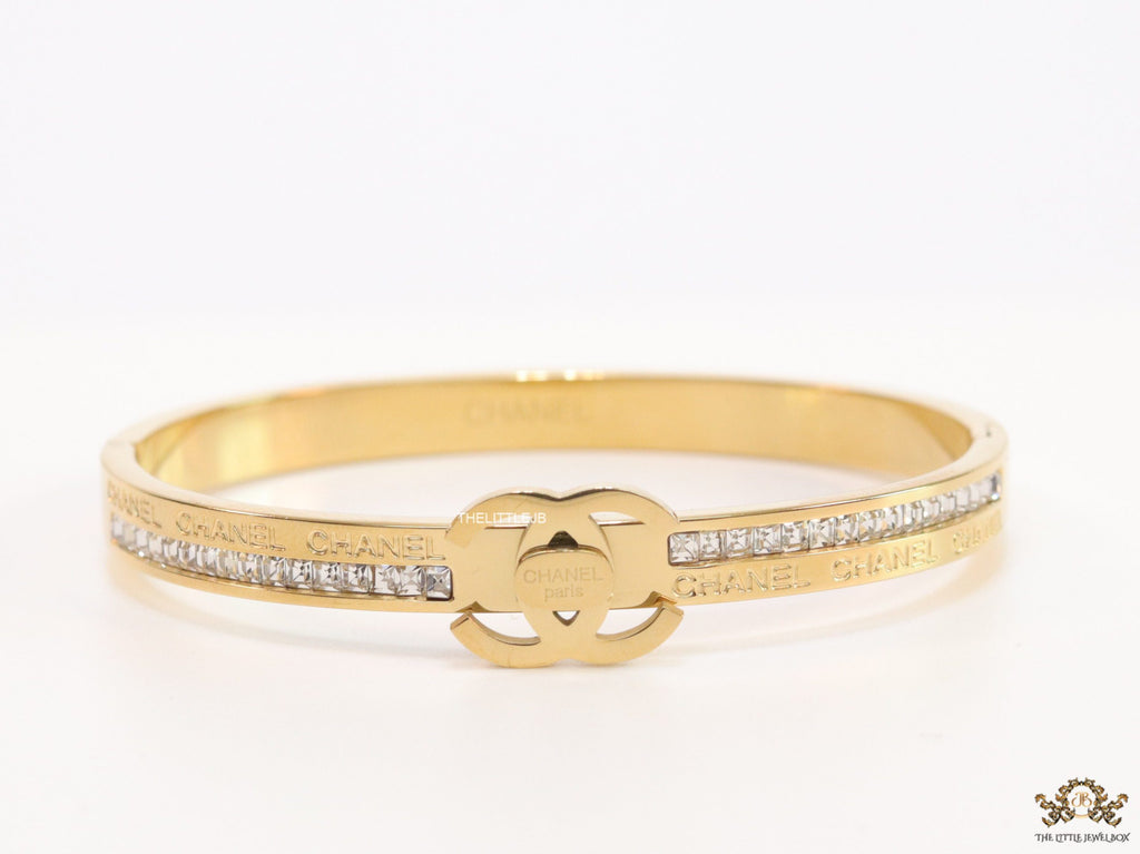 Gold plated bracelet with cz, inscribed alphabets and twin disc motif