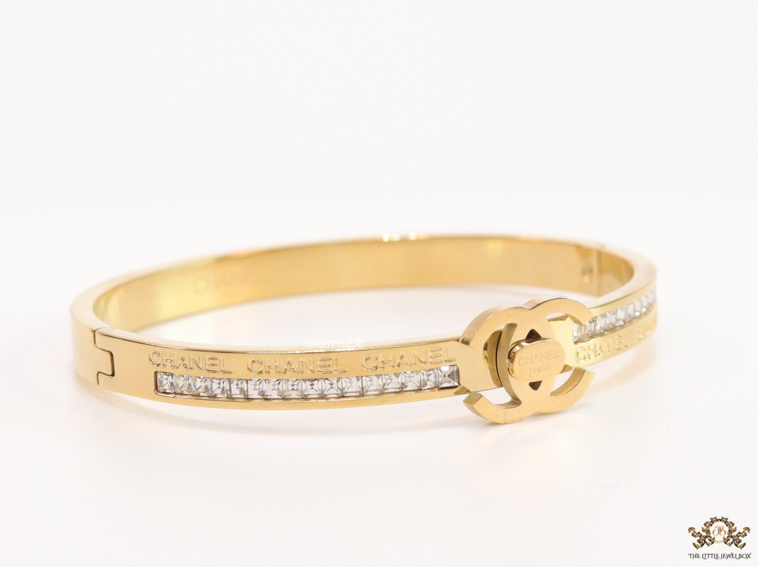 Gold plated bracelet with cz, inscribed alphabets and twin disc motif