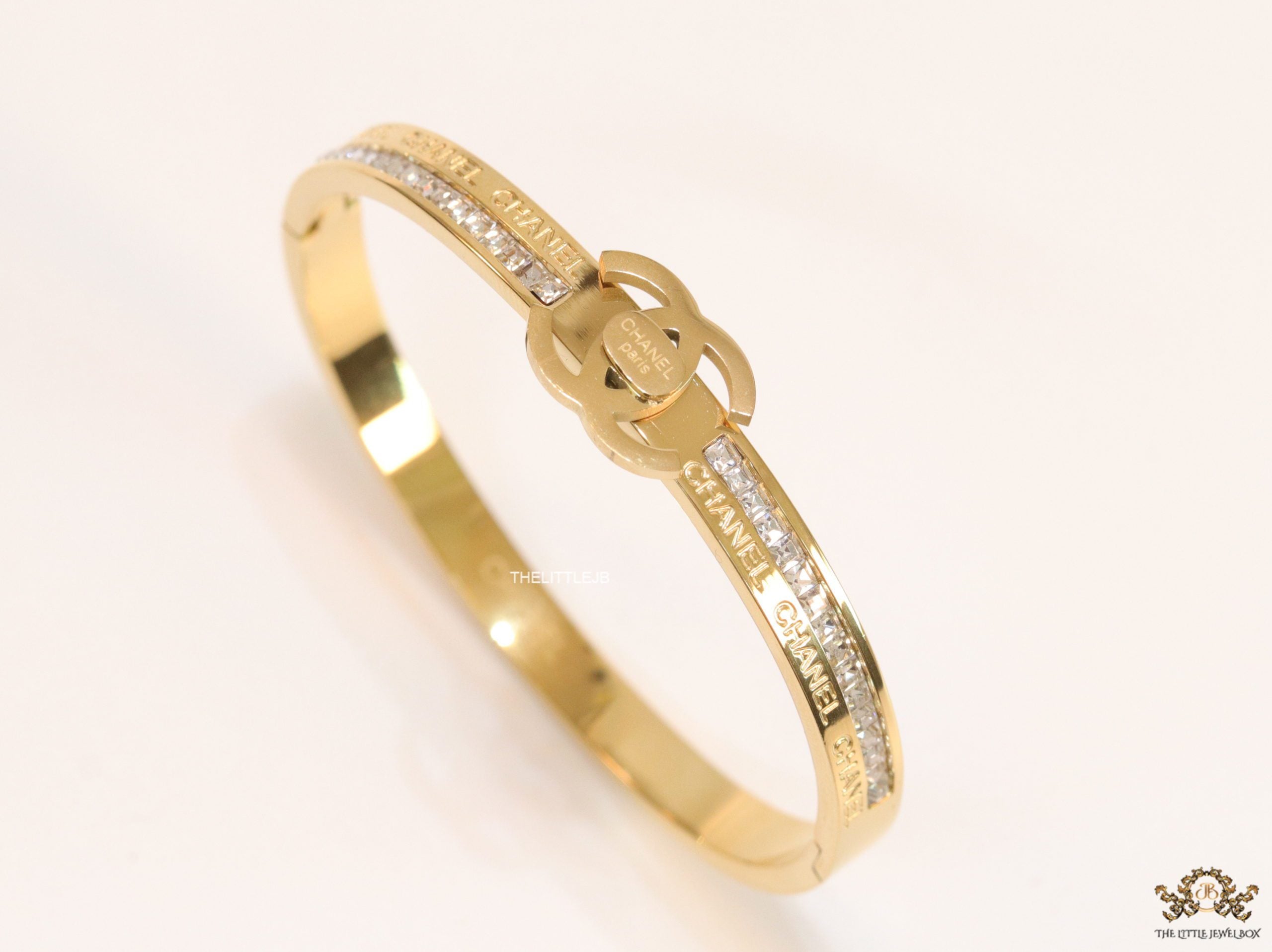 Gold plated bracelet with cz, inscribed alphabets and twin disc motif