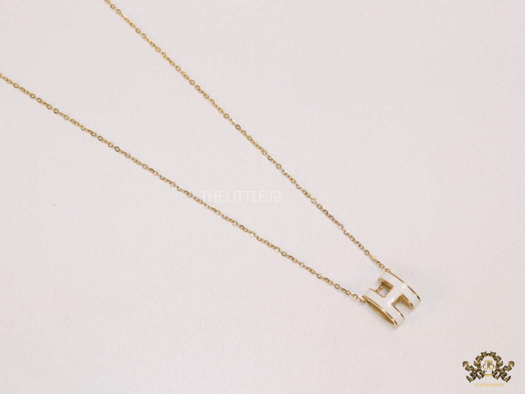 Gold chain necklace with white enamel H motif