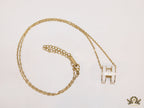 Gold chain necklace with white enamel H motif