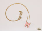 Gold chain necklace with pink enamel H motif