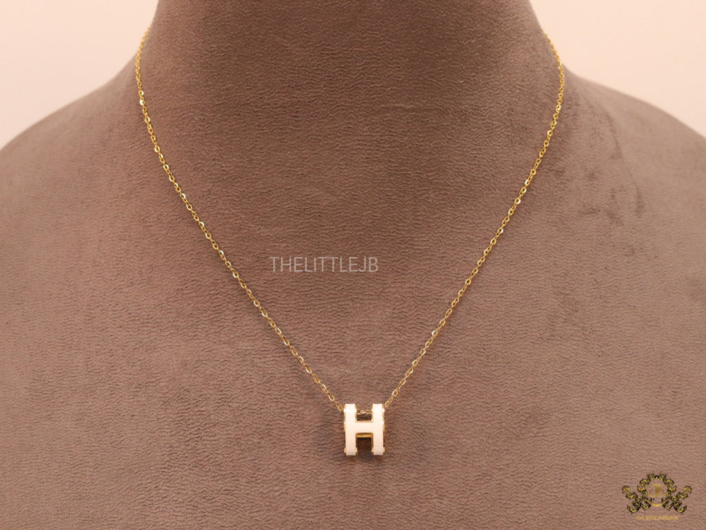 Gold chain necklace with white enamel H motif