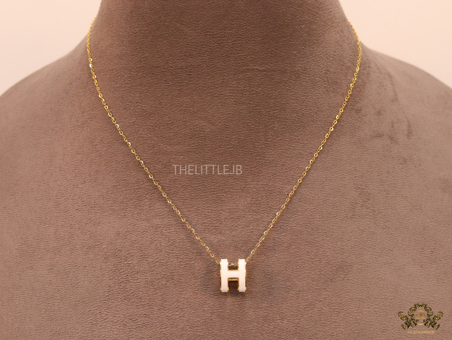 Gold chain necklace with white enamel H motif