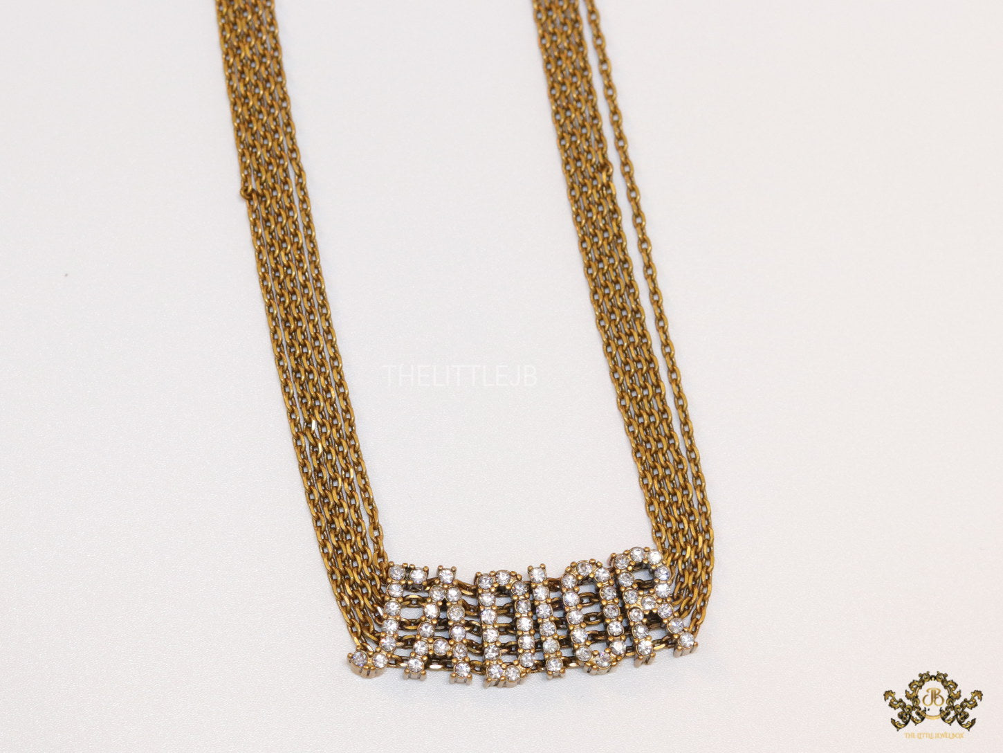 Golden multi chain choker necklace with alphabet motif in cz