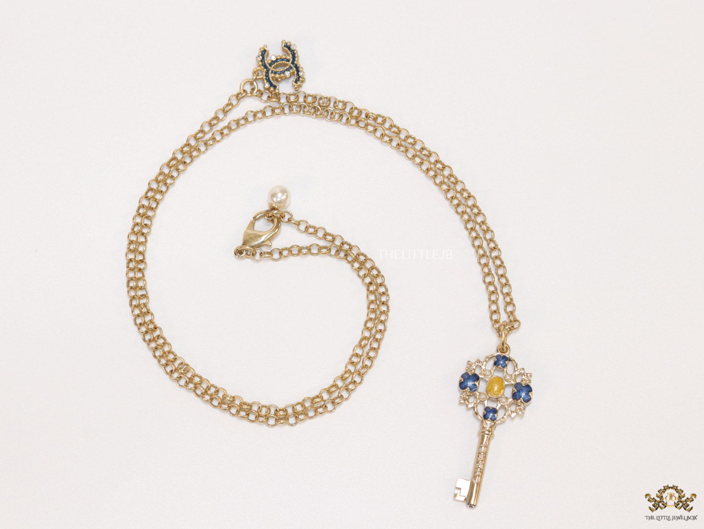 Golden chain necklace with blue clovers studded key pendant
