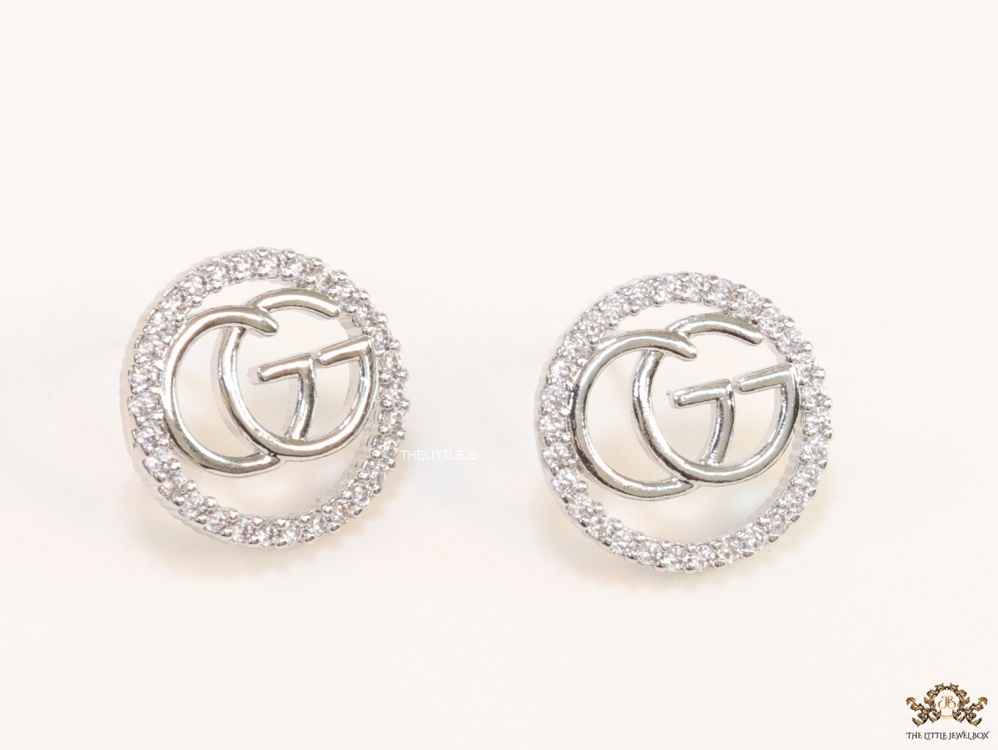 Platinum plated round cz earrings with twin G motif