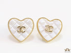 White textured heart shaped studs with twin C motif in golden finish