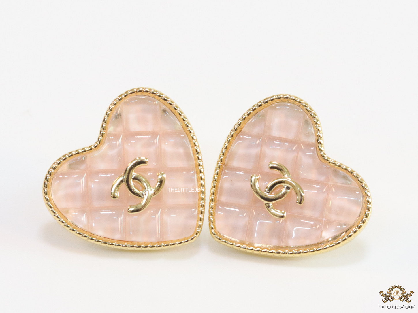 Light pink textured heart shaped studs with twin C motif in golden finish
