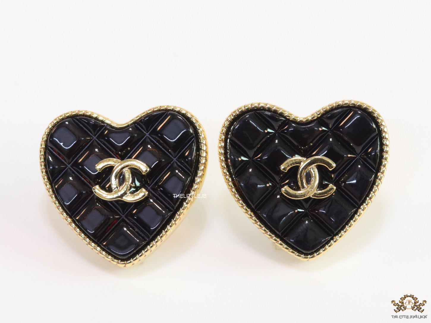 Black textured heart shaped studs with twin C motif in golden finish