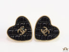 Black textured heart shaped studs with twin C motif in golden finish