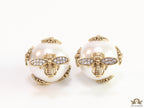 Designer pearl earrings with matte gold flying bee motifs