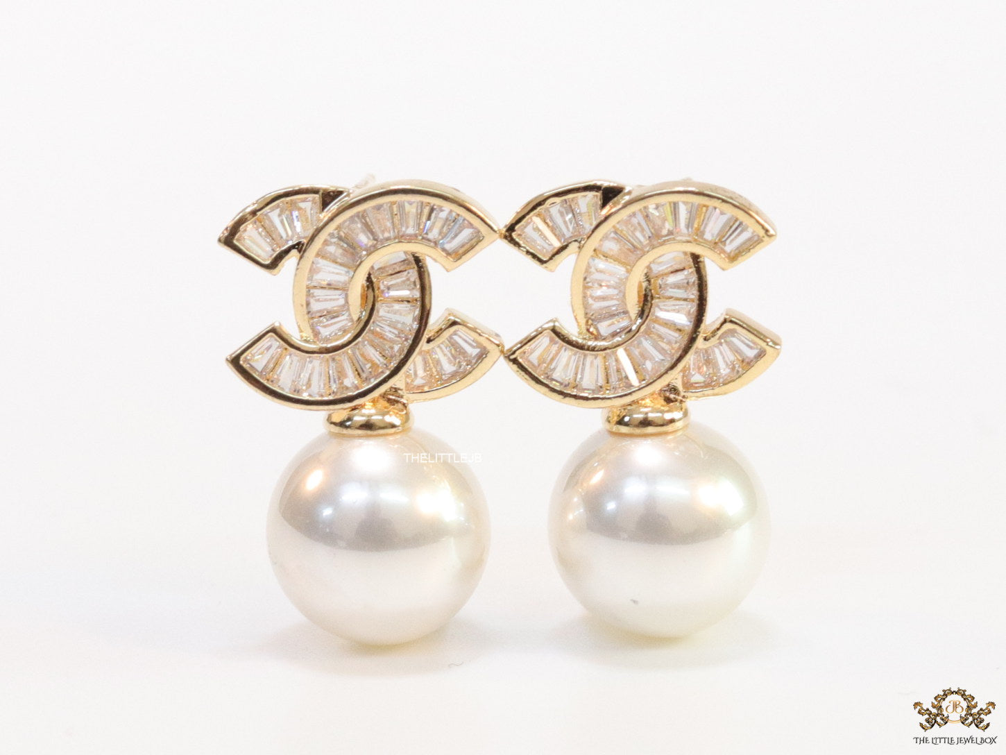 Golden cz baguettes studded twin C motif stud with pearl drop