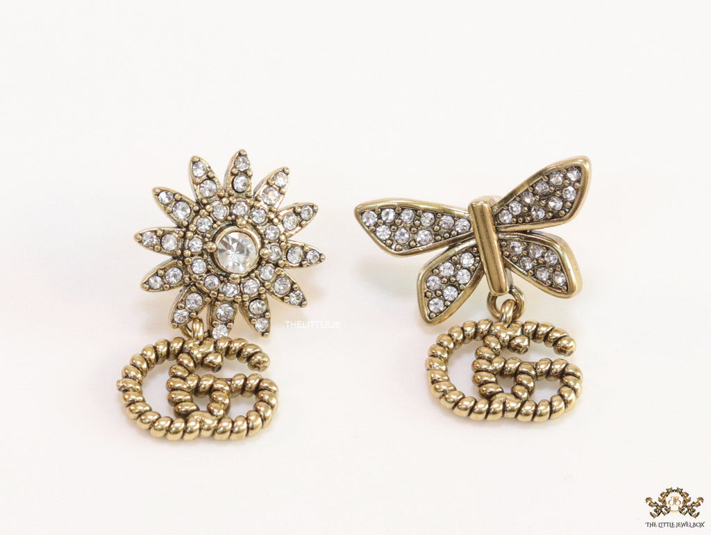 Flower and butterfly cz earrings in antique gold with twin G drops