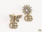 Flower and butterfly cz earrings in antique gold with twin G drops