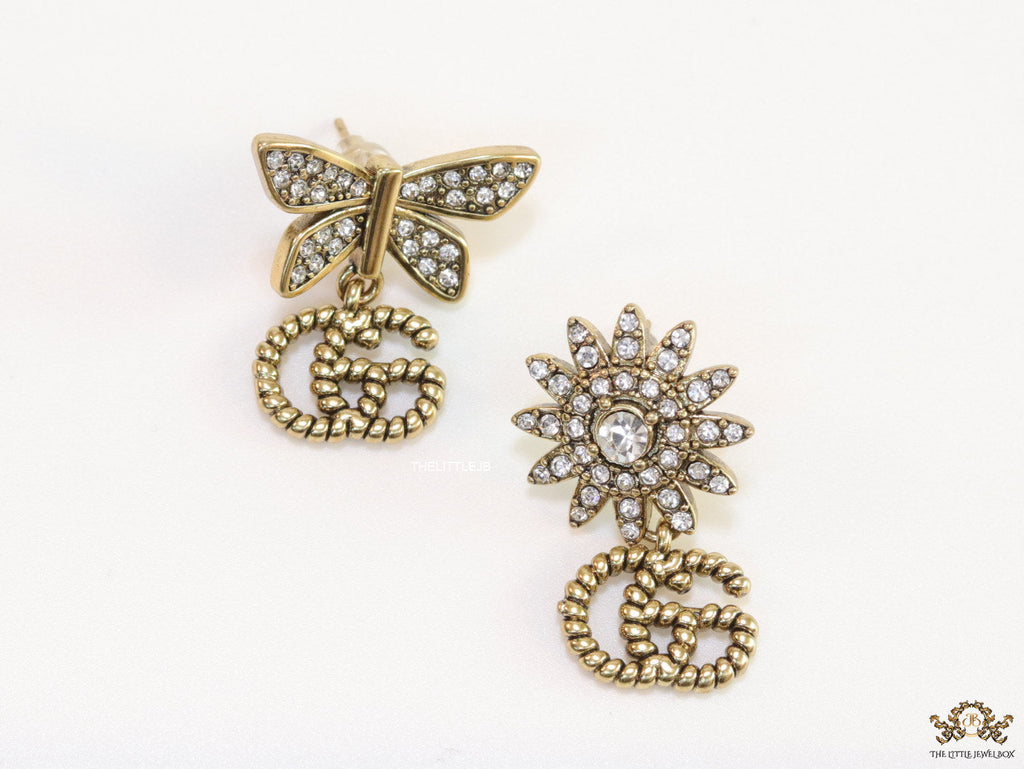 Flower and butterfly cz earrings in antique gold with twin G drops