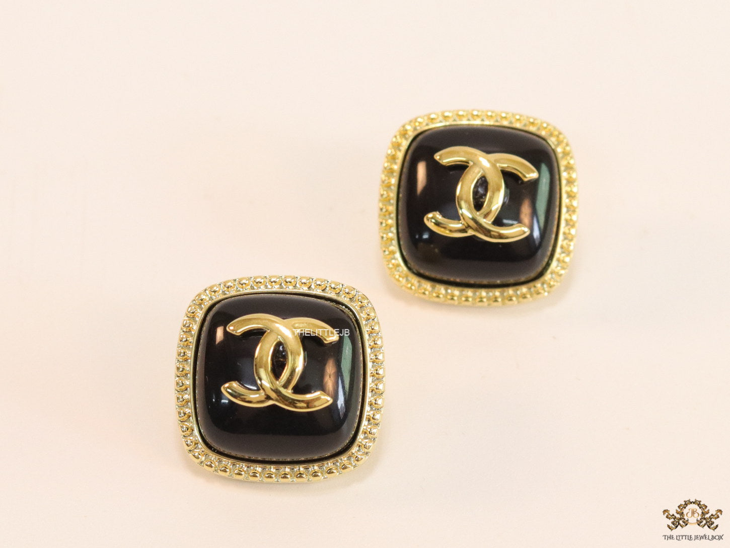 Twin C motif square studs in golden and black finish