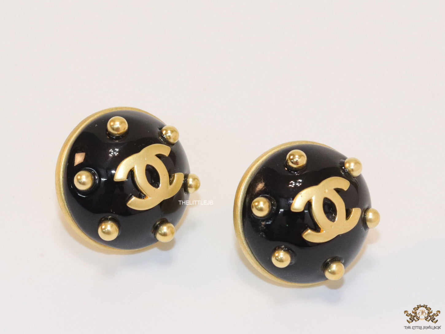 Black and golden twin C motif round stud earrings