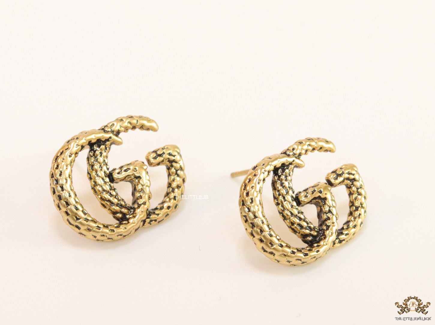 Double G motif studs with woven basket texture in antique gold finish