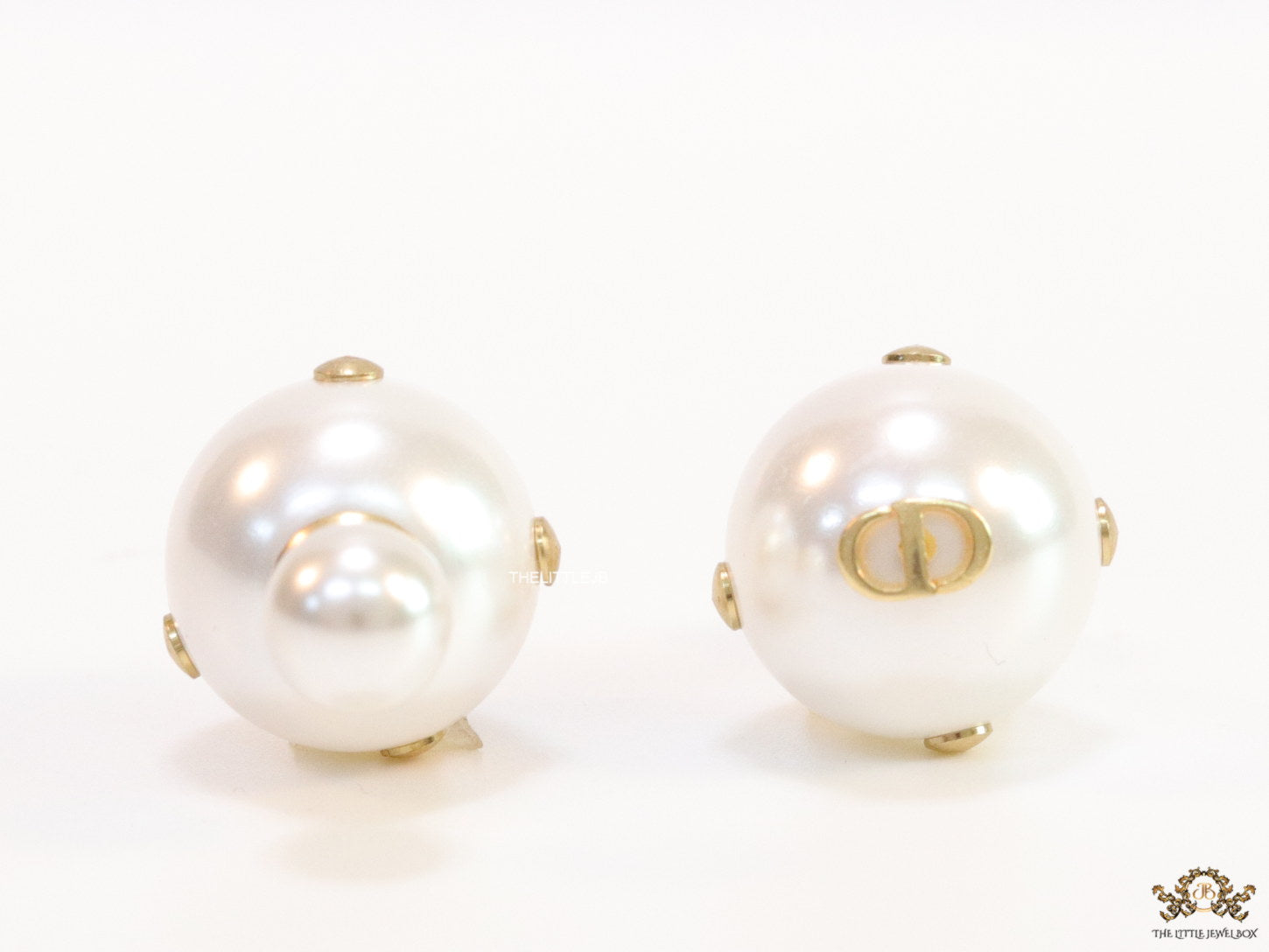 White pearl studs with golden alphabet motif and golden details